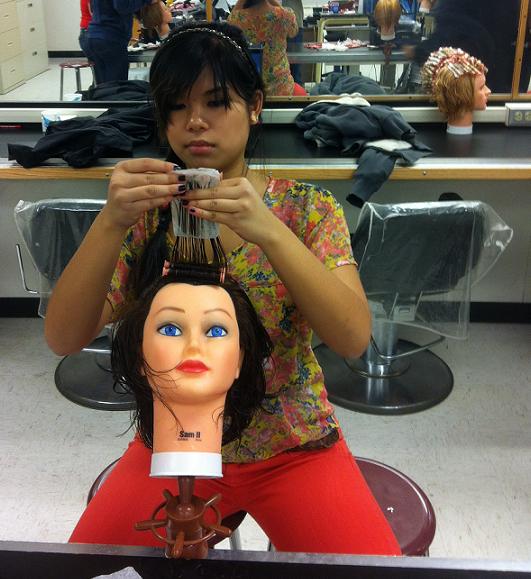 Sabrina Tran practices her styling on a mannequin in her Hairstyling 1 class at Boulder TEC.