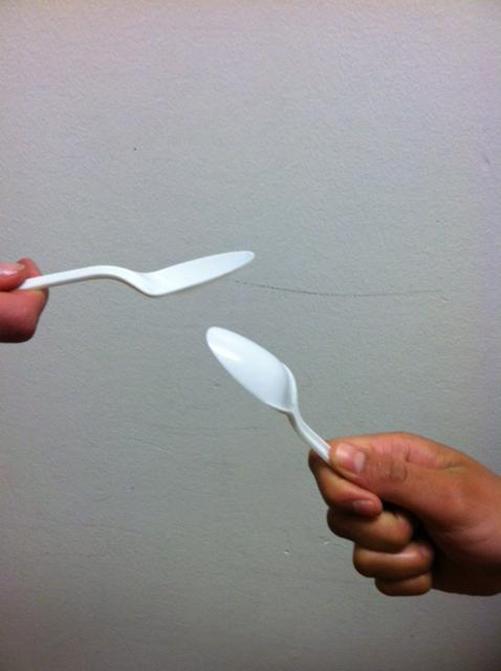 Photo illustration of two spoons battling. 