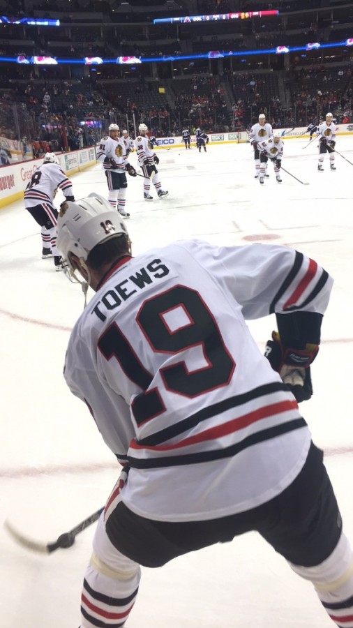 Leaning forward, Hawks captain Jonathan Toews prepares to dish out a pass to one of his teammates during warmups at the December 31st game against the Avalanche at Pepsi Center in Denver. The Blackhawks got their winning streak going with a 4-3 OT win to kick off the new year. Since then, the Hawks have not lost a game, and their streak is changing the standings and putting them in contention for a back-to-back cup win.