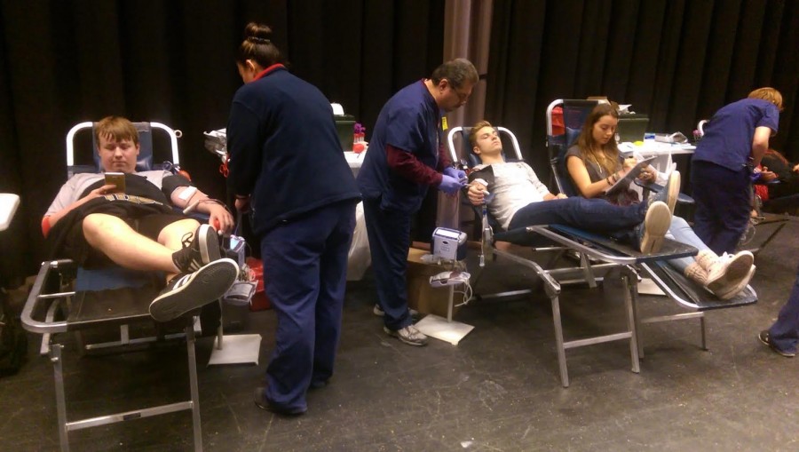 Students Michael Kasten, Simone Foreman, Jacob Kennedy donate blood at the semiannual blood drive.