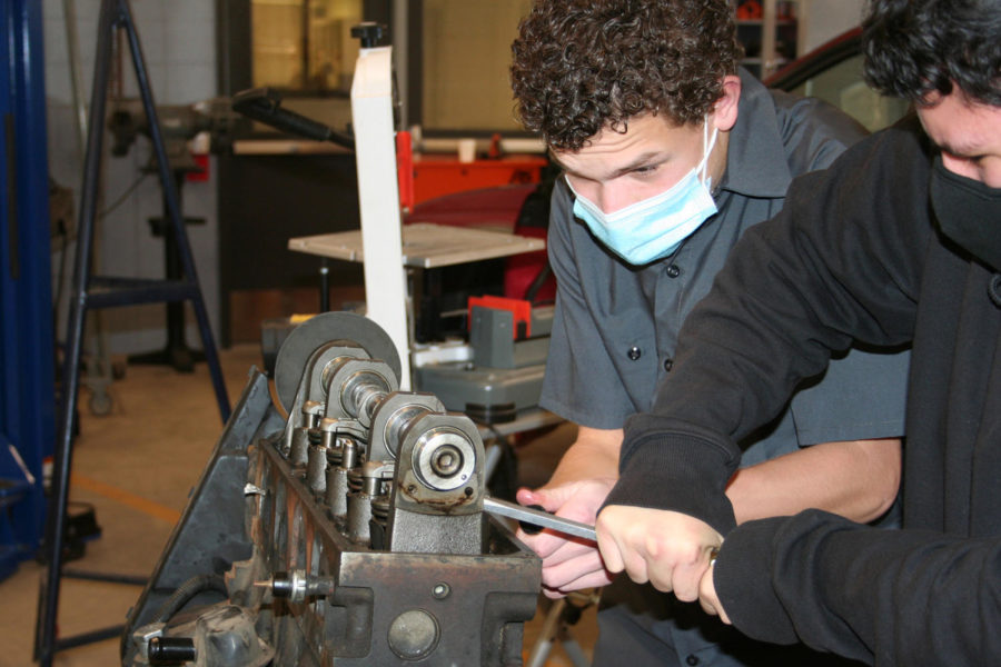 In the automotive class at Boulder TEC, Isaac Epp ‘23 repairs a car engine.