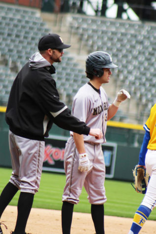 Coach James Thompson talks to Daniel Schenkel ‘22 at Coors Field on  March 16.