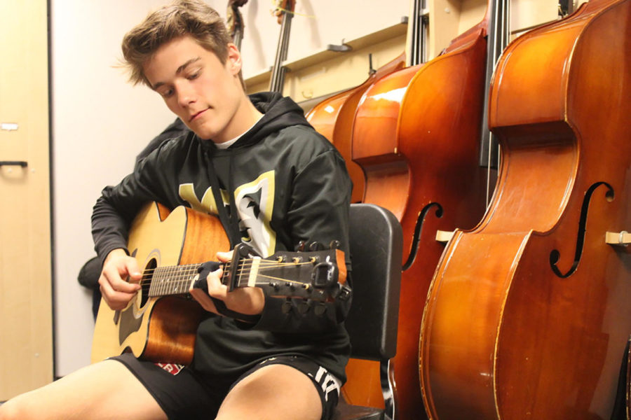 Cooper Craze ‘26 plays his guitar in a practice room before school. He joined Monarch’s top choir, Madrigals, this year.