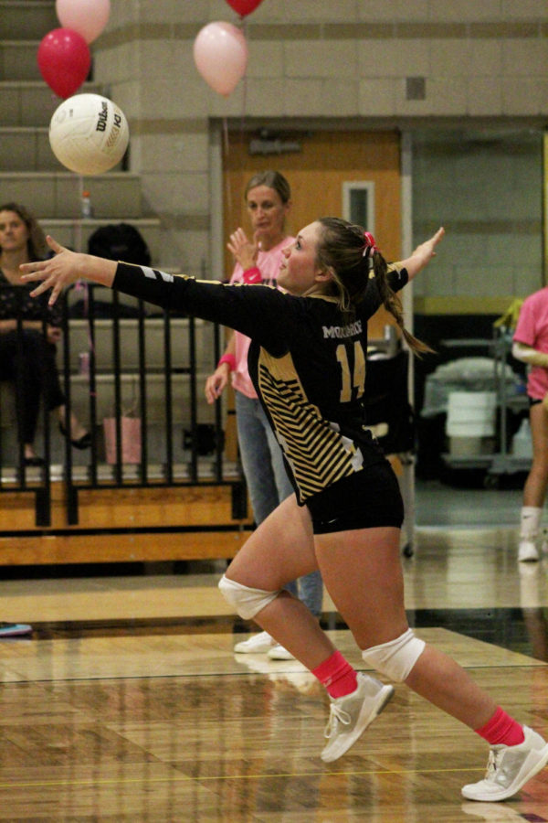 Eva Becht ‘26 serves a volleyball during her game. She tried out for the team in August and made varsity.