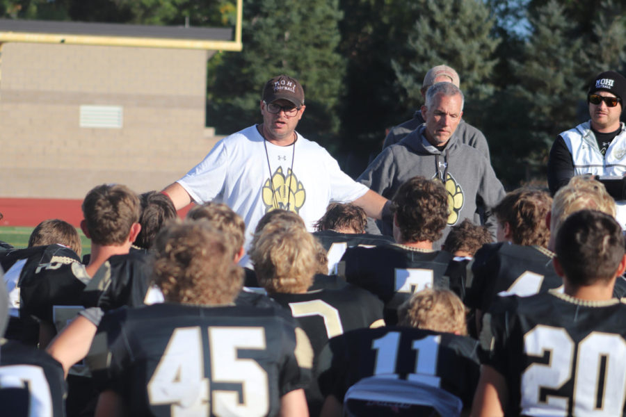 Football coach, Aaron Paddock, gives a pep talk to the team. He has led the team to many victories so far.
