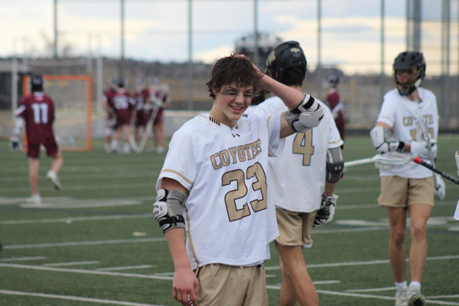 Flynn Leonard ‘25 takes his helmet off to cool down at halftime against Cherokee Trail. He scored three goals and had two assists during the game.