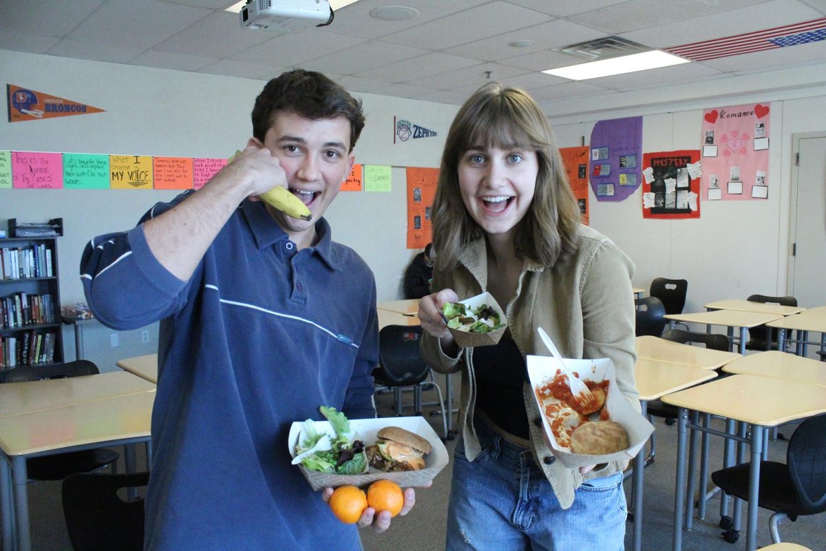 Bea Lighthiser ‘24 and Jack Bedard ‘25 pose for a picture with their hot lunches. The trays contain not only a main entree, but also many of the sides that the hot lunch offers. This food will soon be reviewed on @mohi_munchies.