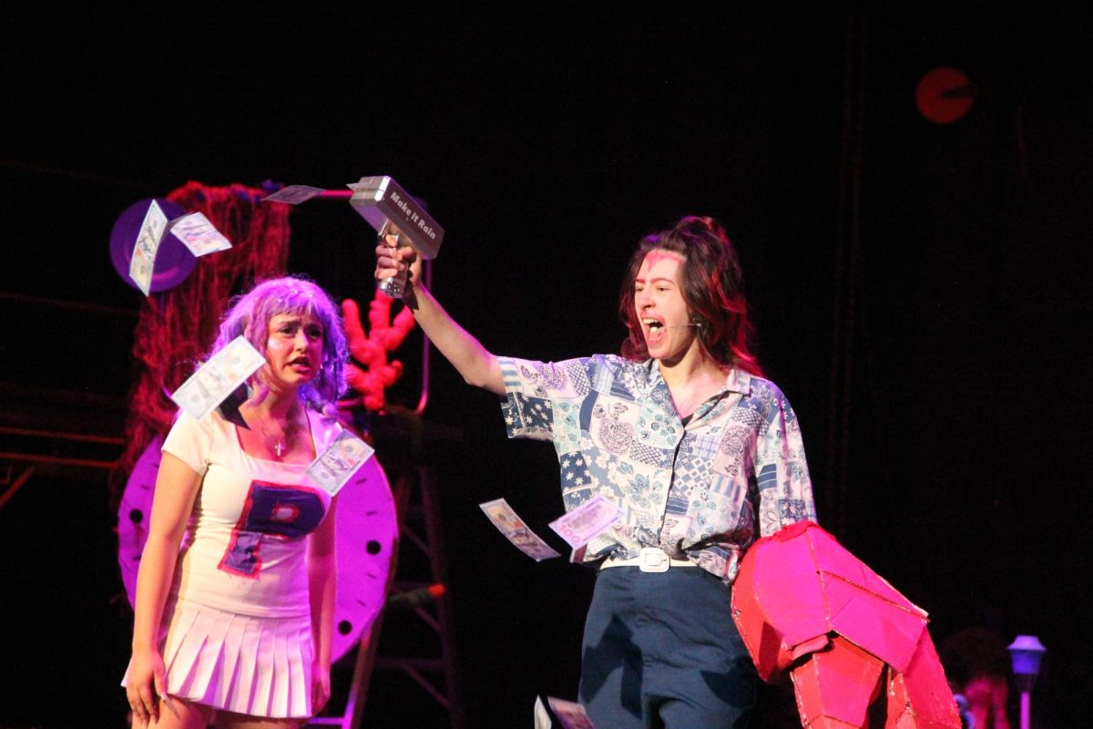 Playing Mr. Crabs in the Spring Musical SpongeBob The Musical, Patrick Shiffler (12) shoots his money gun while Addison Rood (9) looks on. Shiffler has found refuge in the theater community after struggles early in high school.